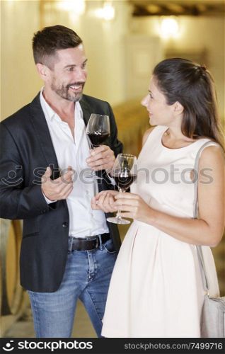 elegant couple drinking wine in a cellar