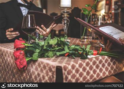 Elegant couple in love reading a menu during a romantic dinner in a restaurant in close-up (selective focus)