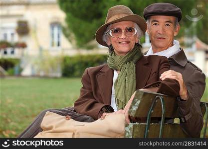 Elegant couple sitting on a park bench