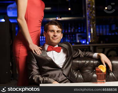 Elegant couple. Young handsome man in bar accompanied by elegant lady