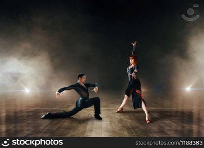 Elegant dancers, latin ballrom dance on stage. Female and male partners on professional pair dancing on scene