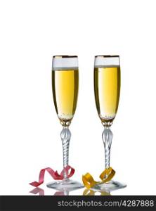 Elegant drinking glasses filled with golden champagne isolated over white background with reflection and party ribbons