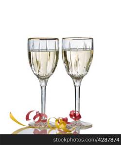 Elegant drinking glasses filled with white wine isolated over white background with reflection and party ribbons