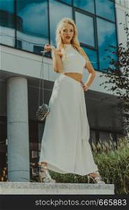 Elegant fashionable woman presenting trendy urban outfit. White crop top and trousers culottes.. Woman wearing crop top and culottes