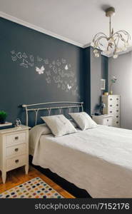 Elegant furnished double bedroom with bed, bedside tables and symphonier. Elegant furnished double bedroom interior