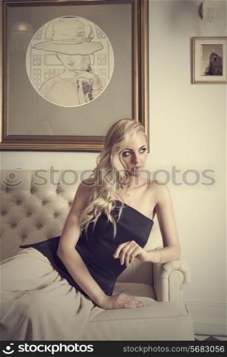 elegant girl with curly hair , sitting on white sofa , in luxury interior , she is looking on one side&#xA;