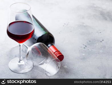 Elegant glass and bottle of red wine on kitchen table background.