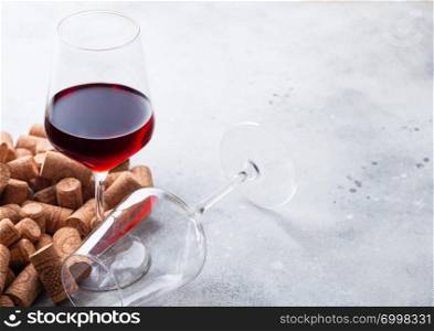 Elegant glass of red wine with corks on kitchen table background.