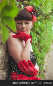 Elegant lady in red gloves and polka dot dresses posing for photo. Retro fashion woman