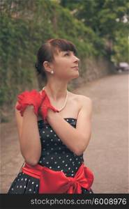Elegant lady in red gloves and polka dot dresses posing for photo. Retro fashion woman