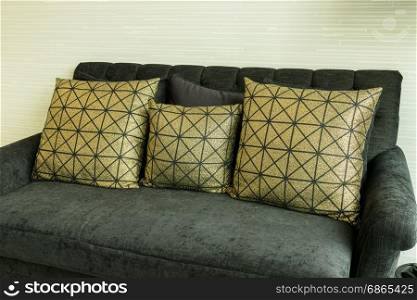 elegant living room interior with golden pattern pillows on black velvet sofa