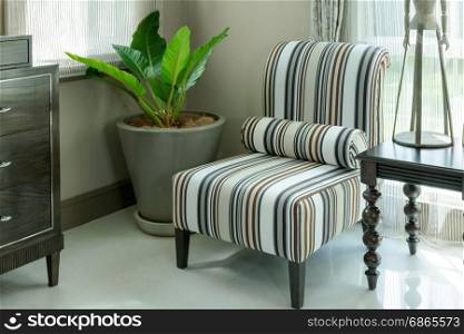 elegant living room interior with striped pattern pillows on armchair