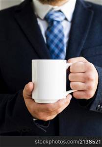 elegant man holding up mug