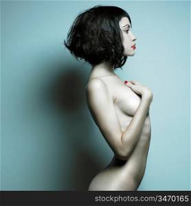 Elegant nude woman with curly hair. Studio portrait.