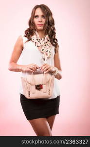 Elegant outfit. Female fashion. Girl in fashionable clothes holding bag handbag studio shot on pink background