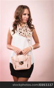 Elegant outfit. Female fashion. Girl in fashionable clothes holding bag handbag studio shot on pink background