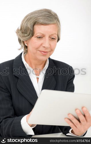 Elegant senior businesswoman working on touch-screen tablet computer