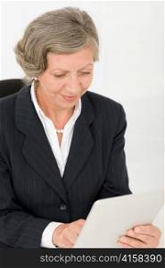 Elegant senior businesswoman working on touch-screen tablet computer