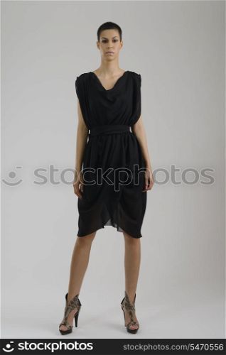 elegant woman in fashionable stylish dress posing in the studio