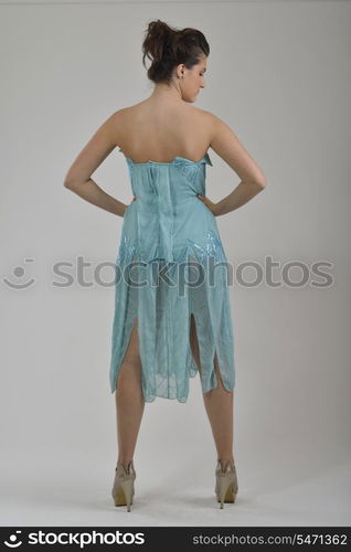 elegant woman in fashionable stylish dress posing in the studio