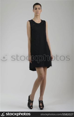 elegant woman in fashionable stylish dress posing in the studio