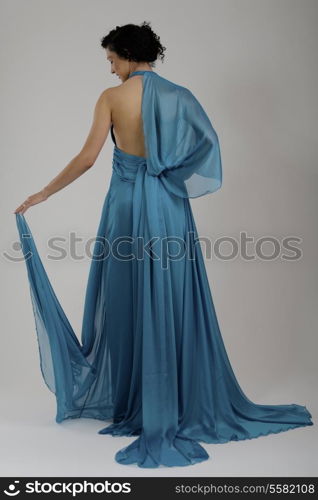 elegant woman in fashionable stylish dress posing in the studio