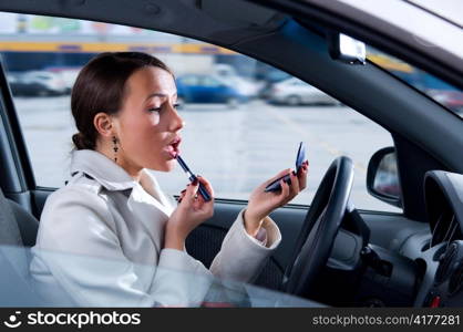 elegant woman is doing makeup on the run in her car