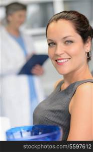 Elegant woman patient at dental surgery smiling dentist in background