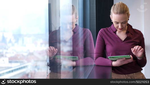 Elegant Woman Using Mobile Phone by window in office building