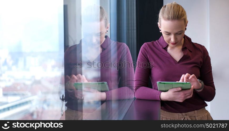 Elegant Woman Using Mobile Phone by window in office building