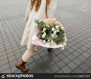 elegant woman walking city holding bouquet flowers