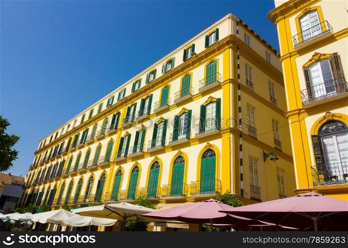 elegant yellow houses with green windows in the city of Malaga, Spain