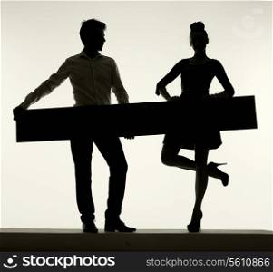 Elegant young couple holding the empty board
