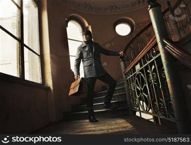 Elegant young guy holding a briefcase