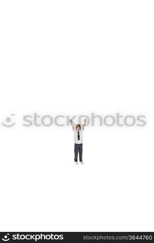 Elementary boy standing at distance with arms raised over white background