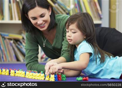 Elementary Pupil Counting With Teacher In Classroom