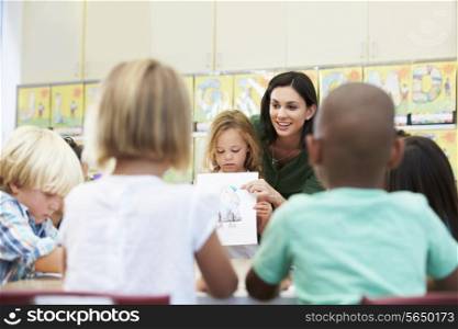 Elementary Pupil Showing Drawing To Classmates In Classroom