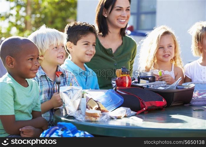 Elementary Pupils And Teacher Eating Lunch