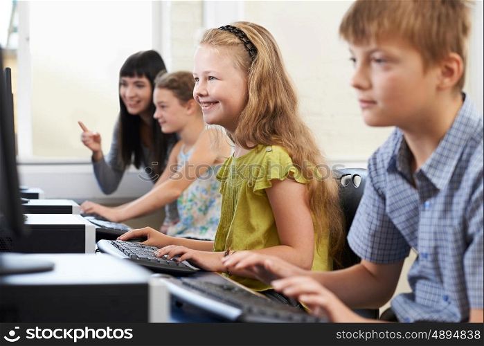 Elementary Pupils In Computer Class With Teacher