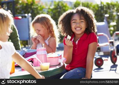 Elementary Pupils Sitting At Table Eating Lunch