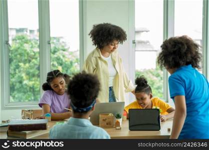 Elementary school,African American school children studying together using tablet device in classroom,Technologies for education concept.