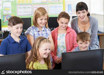 Elementary School Pupils With Teacher In Computer Class