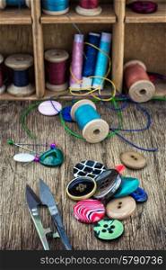 elements of needlework. set of threads and buttons on wooden background.Selective focus