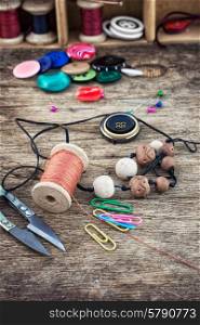 elements of needlework. set of threads and buttons on wooden background.Selective focus