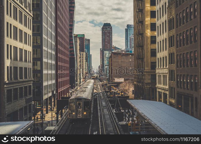 Elevated Train Tracks are running above the Railroad tracks between the building at the Loop line at Chicago, Illinois, USA