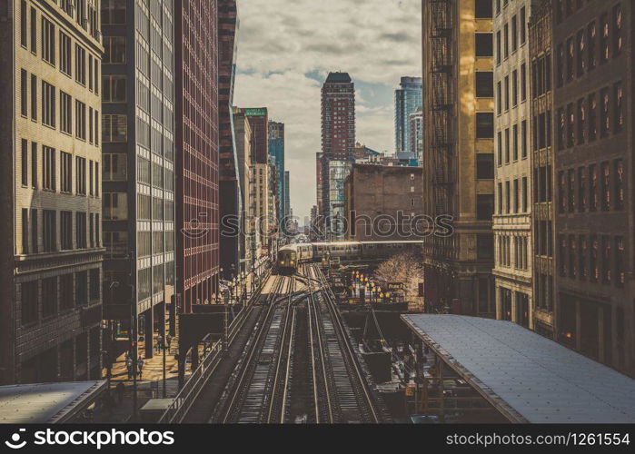 Elevated Train Tracks are running above the Railroad tracks between the building at the Loop line at Chicago, Illinois, USA