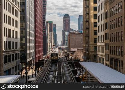 Elevated Train Tracks are running above the Railroad tracks between the building at the Loop line at Chicago, Illinois, USA