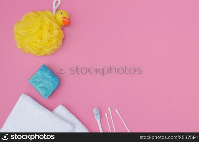 elevated view bath sponge soap cotton swab towel pink background