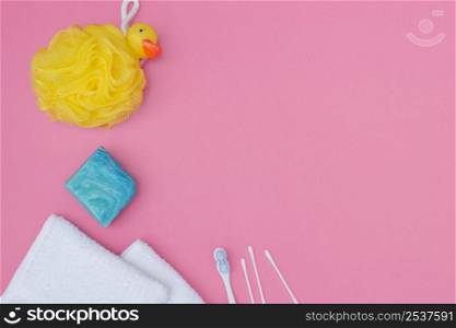 elevated view bath sponge soap cotton swab towel pink background