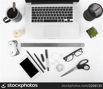 elevated view black coffee laptop cellphone stationeries white backdrop